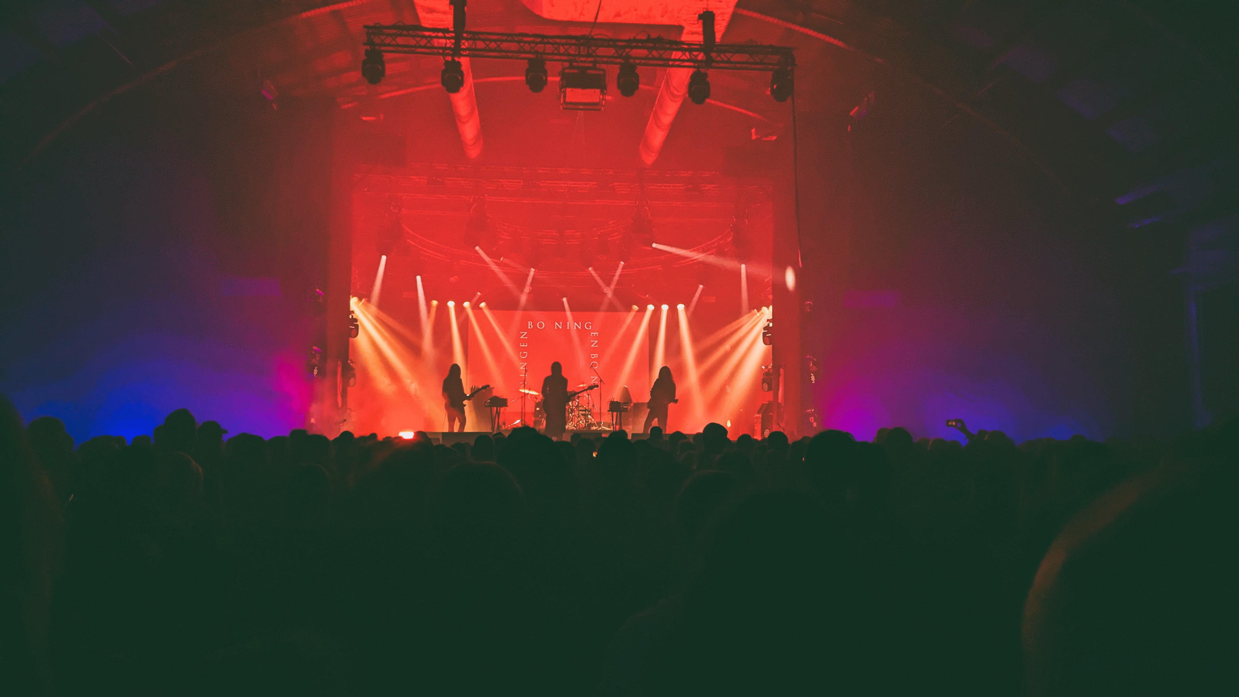 A live performance at the Roadburn music festival, featuring a band on stage with colorful lights and an audience in silhouette.