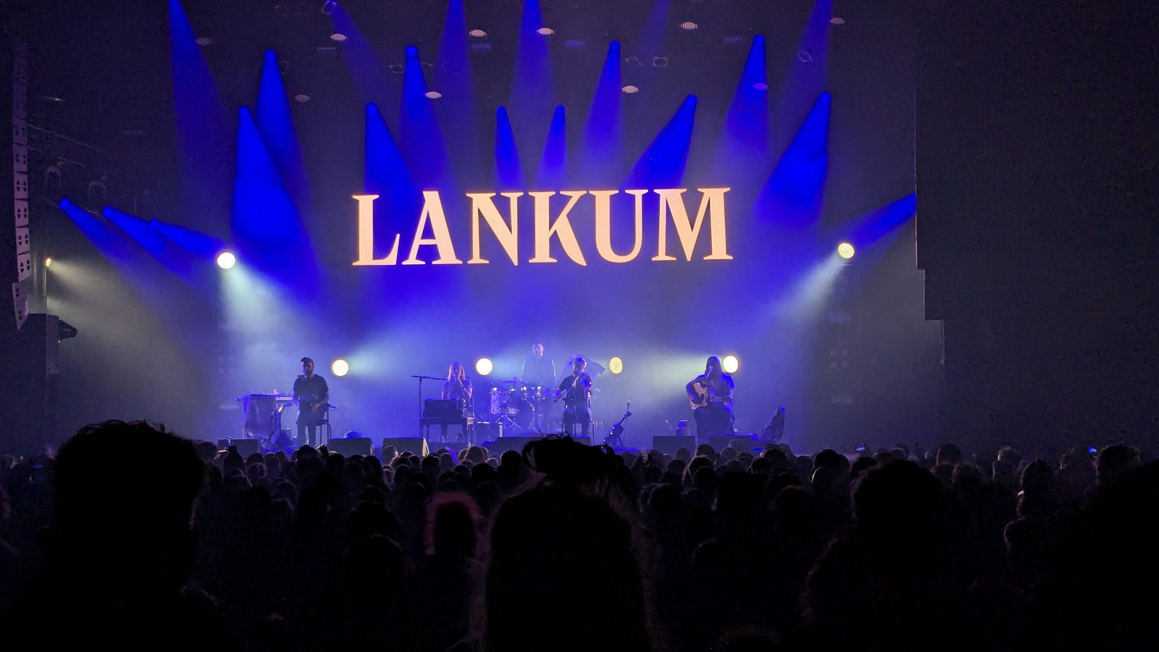 A live performance at the Roadburn music festival featuring the band Lankum, with vibrant stage lighting and an enthusiastic audience.