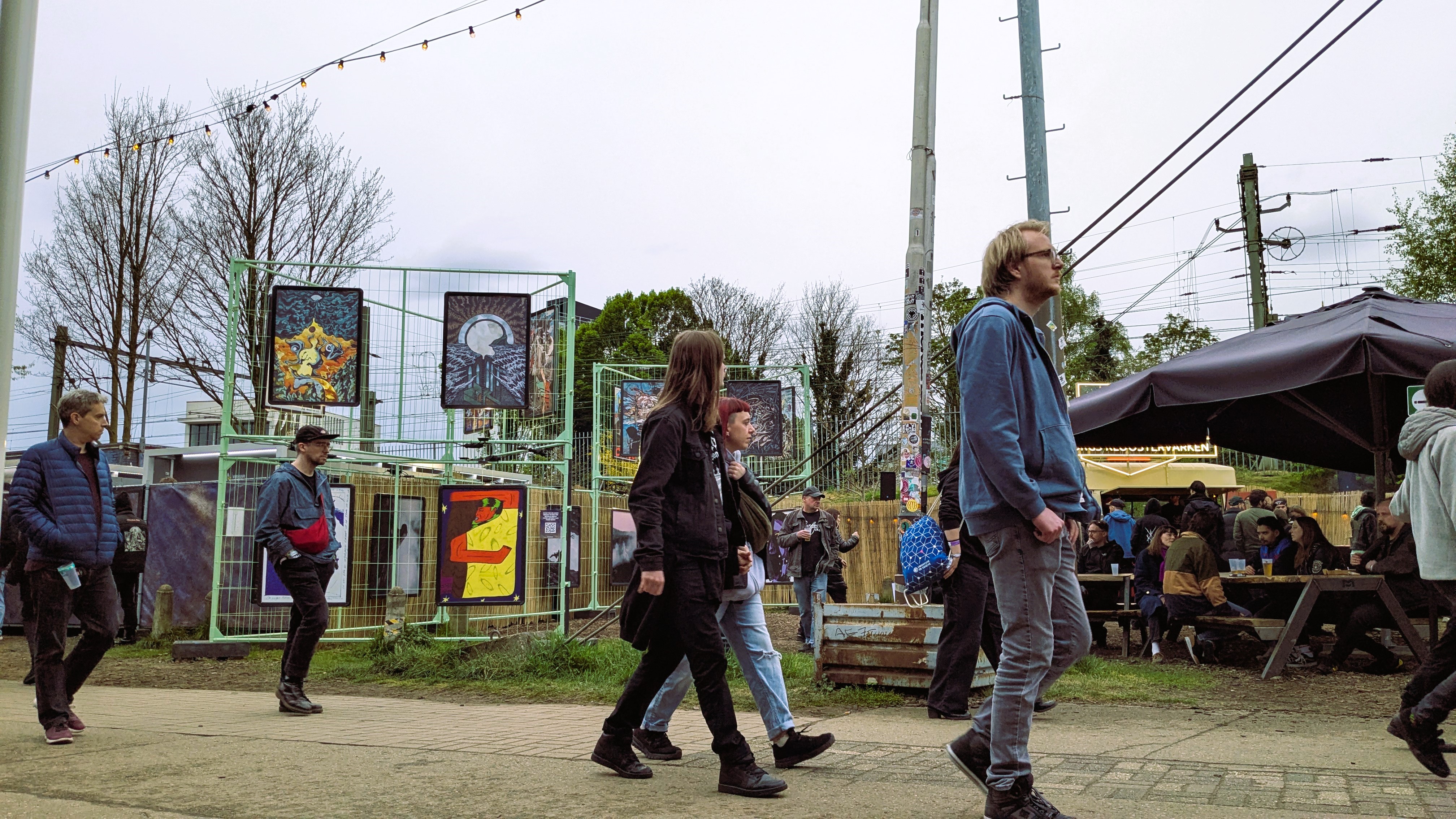 Attendees walking past colorful art displays at the Roadburn music festival.